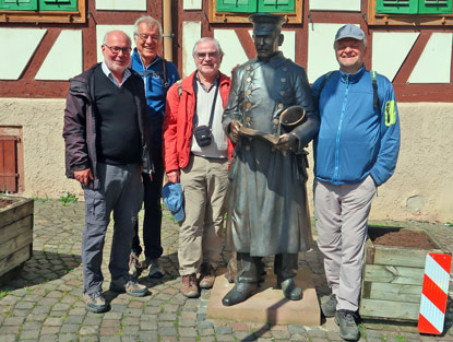 Der Ausscheller am Markplatz von Gro-Ostheim mit vier Wanderer aus dem Raum Heidelberg