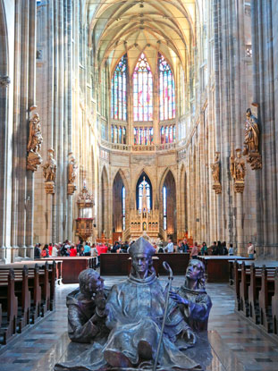 Gegenber dem Haupteingang erhebt sich seit Mai 2018 eine Statuengruppe aus Silber, die den heiligen Adalbert darstellt. Er ist begleitet von seinem Halbbruder Radim und seinem Lehrer Radla 