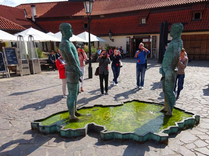 Im Hof des Kafka-Museums urinieren zwei Mnner in ein Wasserbecken, das die Form Tschechiens aufweist.