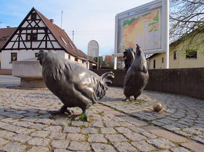 Am (neuen) Dorfbrunnen von Eichelberg mit seinen freilaufenden Hühnern. 