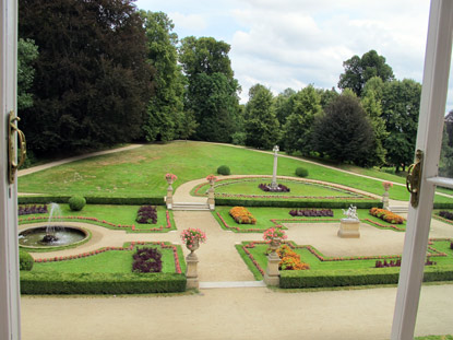 Blick aus einem Schloss-Fenster auf den gepflegten Garten