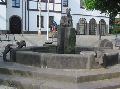 Rheinburgenweg: Der aus Basalt erbaute Brunnen vor dem Rathaus  von Brohl